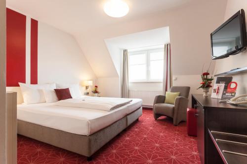 um quarto de hotel com uma cama e uma televisão em Best Hotel ZELLER em Königsbrunn