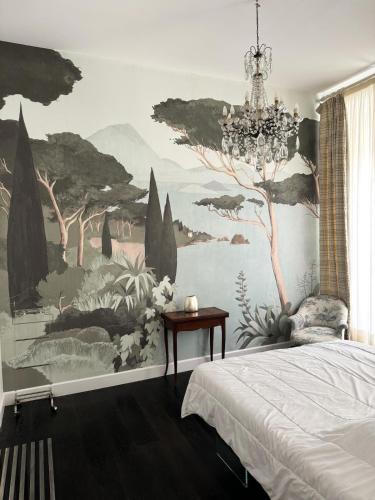 une chambre avec un grand tableau sur le mur dans l'établissement Carré d'Or, superbe apartment sur jardin, élégant et ensoleillé, à Nice