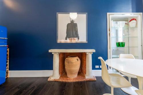 une chambre bleue avec une table et un vase dans l'établissement Carré d'Or, superbe apartment sur jardin, élégant et ensoleillé, à Nice
