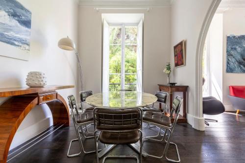 une salle à manger avec une table et des chaises en verre dans l'établissement Carré d'Or, superbe apartment sur jardin, élégant et ensoleillé, à Nice