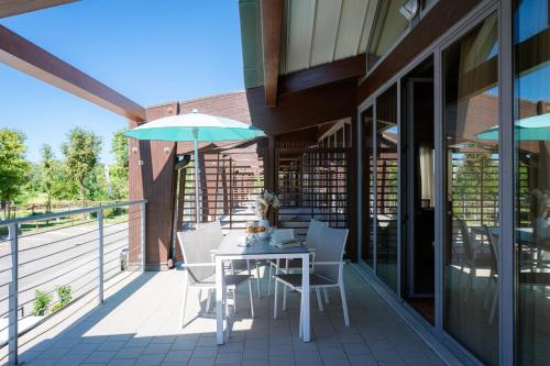 a patio with a table and an umbrella at Club del Sole Tenuta Primero Grado Family Collection in Grado