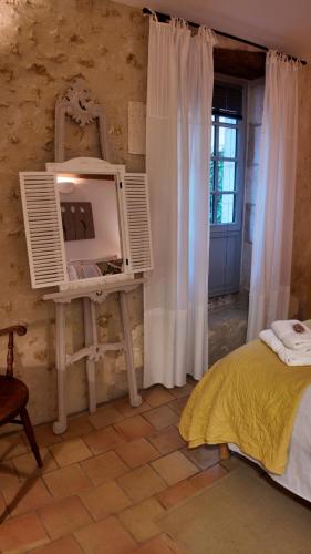 a bedroom with a bed and a mirror and a window at Repos à Ribérac B&B in Ribérac