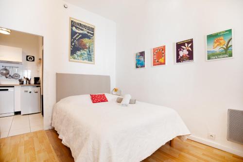 Cet appartement comprend une chambre avec un lit blanc et une cuisine. dans l'établissement Charmant Apt proche du parc Simone Veil, à Sète