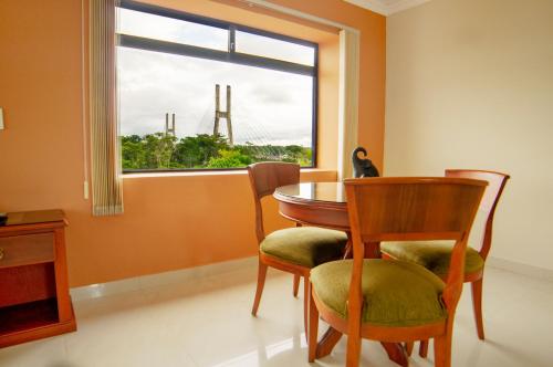 a dining room with a table and chairs and a window at Gran Hotel De Lago - El Coca in Puerto Francisco de Orellana