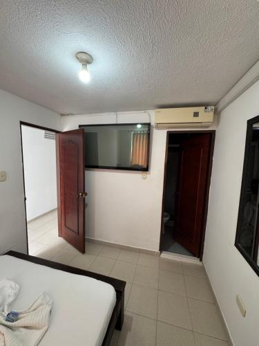 a room with a bed and a window and a door at Hotel el saman in Bucaramanga