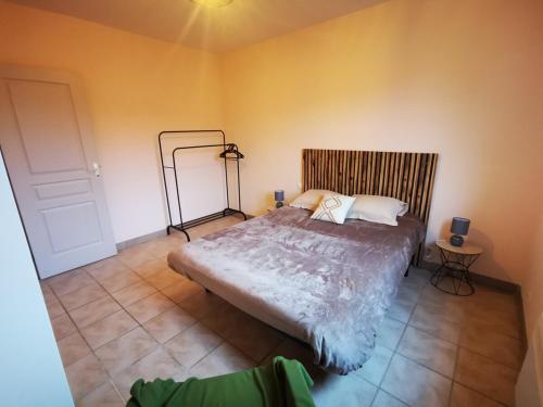 une chambre avec un grand lit dans une pièce dans l'établissement Votre petite maison de vacances, à Saint-Bauzille-de-Putois
