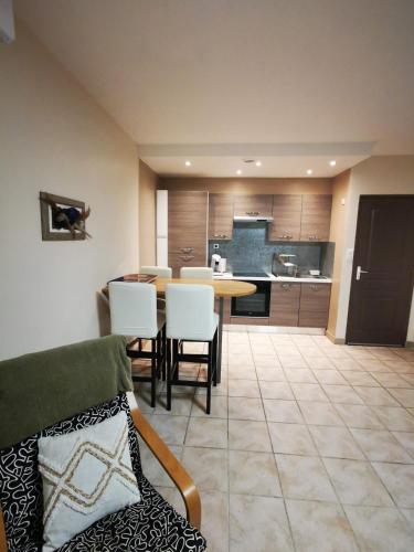 une cuisine et une salle à manger avec une table et des chaises dans l'établissement Votre petite maison de vacances, à Saint-Bauzille-de-Putois