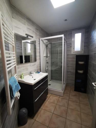 une salle de bain avec un lavabo et une douche dans l'établissement Votre petite maison de vacances, à Saint-Bauzille-de-Putois