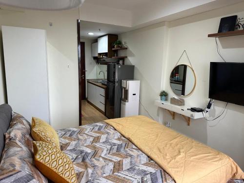 a bedroom with a bed and a mirror and a kitchen at Meisterstad Pollux Habibie Apartment Batam Studio805 in Batam Center