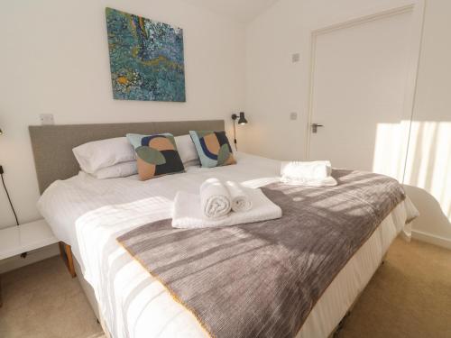 een slaapkamer met een bed met handdoeken erop bij Una, Lodge 70 in St Ives