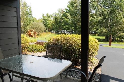 a table and chairs on a porch with a view of a playground at 2 Bedroom accessible condo in Eagle River