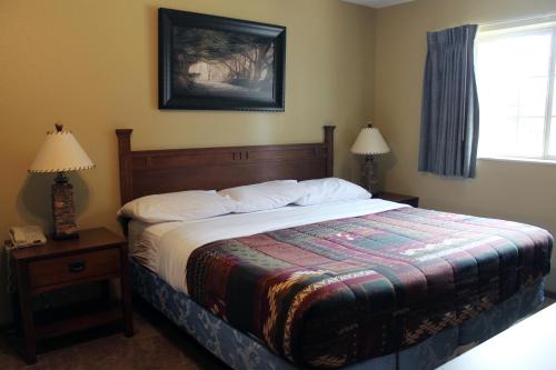 a bedroom with a bed and two lamps and a window at 2 Bedroom Condo at Wild Eagle Lodge in Eagle River