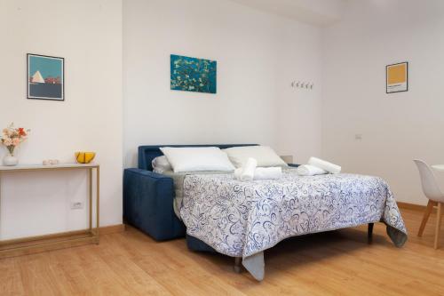 a bedroom with a blue bed and a table at Studio Piramide in Rome