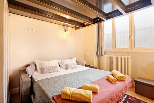 a bedroom with a large bed with yellow towels on it at Dezza Loft in Milan
