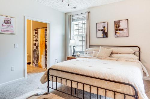 a bedroom with a large bed and a window at 9 Mi to Dtwn Fayetteville Condo with Pool Access! in Hope Mills