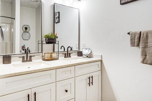 a bathroom with two sinks and a large mirror at 9 Mi to Dtwn Fayetteville Condo with Pool Access! in Hope Mills