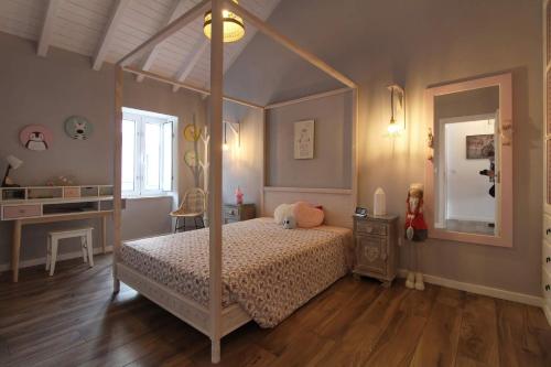 a bedroom with a canopy bed and a desk at Casa Marinda T3 com Piscina in Vila Nova de Milfontes