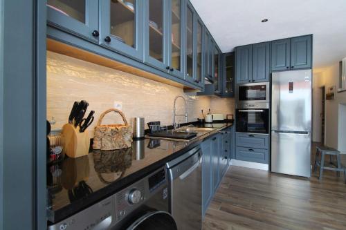 a kitchen with blue cabinets and stainless steel appliances at Casa Marinda T3 com Piscina in Vila Nova de Milfontes