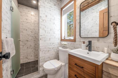 a bathroom with a toilet and a sink and a mirror at CHAMONIX - Micro Chalet with Panoramic Mountain Views near Québec in Lac-Beauport