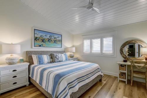a white bedroom with a bed and a window at 608 Sailmaker in Fernandina Beach