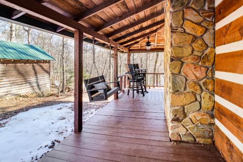 a porch of a cabin with a stone wall at 3 Mi to Dtwn Ellijay Tree-Lined Cabin with Deck! in Ellijay