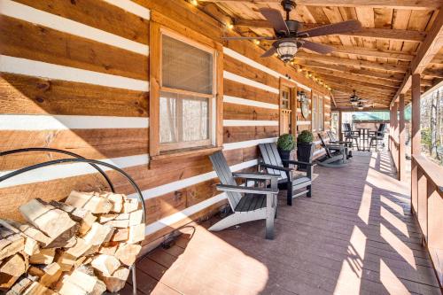 a porch with rocking chairs and a ceiling fan at 3 Mi to Dtwn Ellijay Tree-Lined Cabin with Deck! in Ellijay