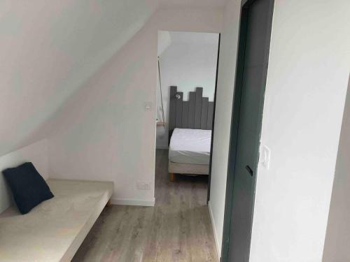 Cette petite chambre mansardée comprend un lit et un miroir. dans l'établissement Gite sur ferme équestre, à Pouldreuzic