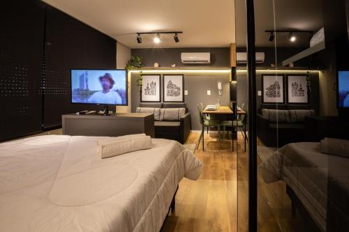 a bedroom with a large bed and a flat screen tv at Loft 613 Canto com garagem in Pelotas