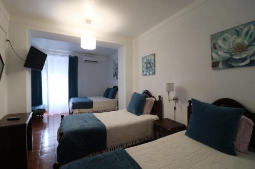 a hotel room with two beds and a window at Residencial Miguel José in Estremoz
