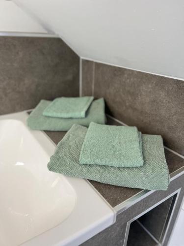 two green towels sitting on top of a bathroom sink at Haus Villa-Moderne Galeriewohnung in Wallersdorf-Haidlfing in Wallersdorf