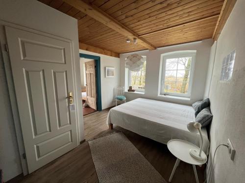 a bedroom with a bed and a window and a door at Deichkieker - charmantes Ferienhaus mit großem Garten in Alleinlage nahe der Nordsee in Ockholm