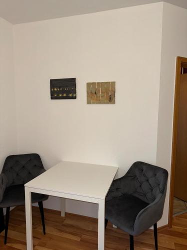 a white table and two chairs in a room at Cozy City Apartment Penzberg in Penzberg