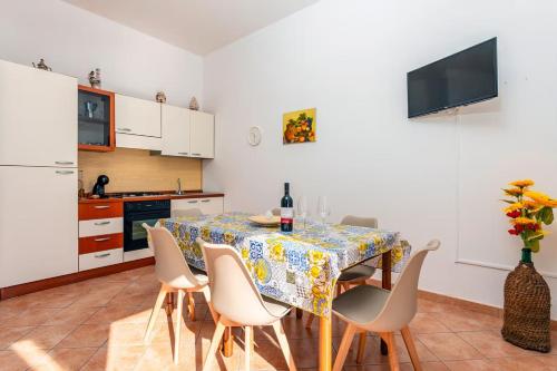 a kitchen with a table with chairs and a refrigerator at Camia Etna House in Piedimonte Etneo