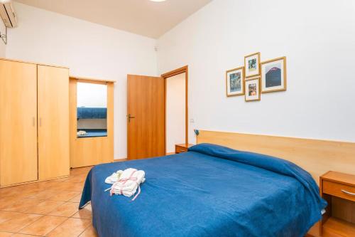 a bedroom with a blue bed with towels on it at Camia Etna House in Piedimonte Etneo
