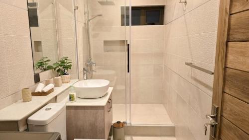 a white bathroom with a sink and a shower at Modern Retreat - Comfort & Style in Hermitage