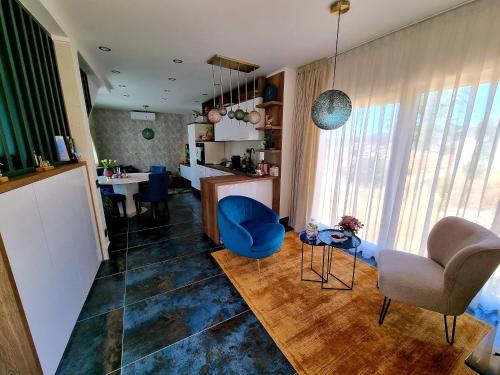 a living room with a blue chair and a table at Vila Santa Maria Hvar with jacuzzi in Jelsa