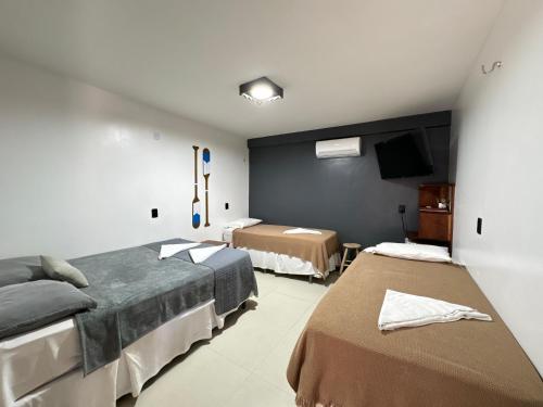 a hotel room with two beds and a tv at Haka Maori Jericoacoara in Jericoacoara