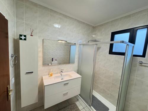 a bathroom with a sink and a shower at Bela Vista House in Ponta Delgada