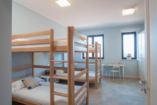 a room with three bunk beds and a table at Fattoria Didattica La Collina Incantata in Narni
