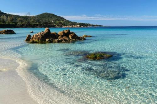 une plage avec des rochers dans l'eau dans l'établissement New 2025 Haut de villa 2 chambres vue mer climatisé à 300 mètres de la mer, à Pietrosella
