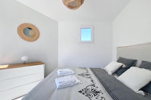une chambre blanche avec un lit et un miroir dans l'établissement New 2025 Haut de villa 2 chambres vue mer climatisé à 300 mètres de la mer, à Pietrosella