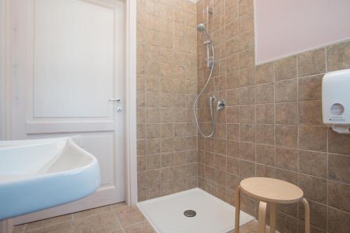 a bathroom with a shower and a sink and a stool at Fattoria Didattica La Collina Incantata in Narni