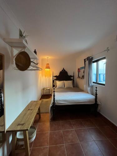 a bedroom with a bed and a wooden table at Casa do Ocaso in Luz