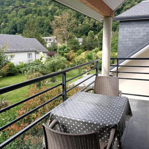 a table and chairs on a balcony with a view at Le balcon des cimes in Adast