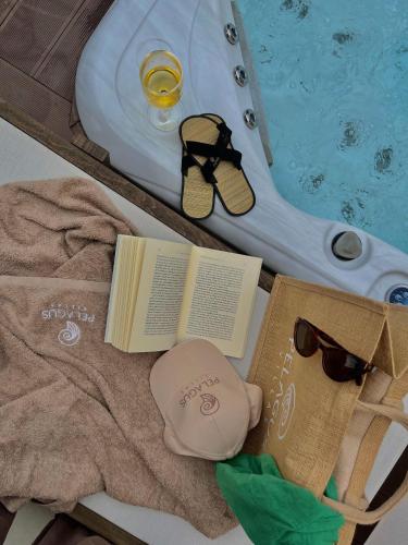 a book and glasses next to a swimming pool at Pelagus Luxury Villas in Polykhrono