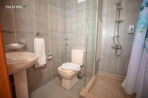 a bathroom with a toilet and a sink and a shower at Palm Inn Hotel Hurghda in Hurghada