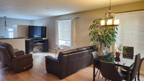a living room with a couch and a table with chairs at Family Friendly 3 Bedroom Unit - Close to Downtown Kingston! in Kingston