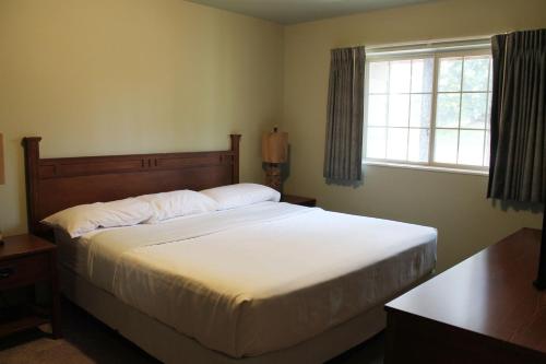 a bedroom with a large white bed with a window at 2 bedroom condo at Wild Eagle Lodge, #133 in Eagle River