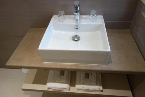 a white sink sitting on a counter in a bathroom at Hotel le Préjoly in Saint-Vallier-de-Thiey