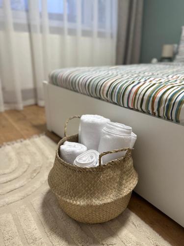 a basket of towels sitting next to a bed at Apartament Cetate Deva in Deva
